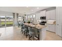 Modern kitchen features white cabinets, stainless steel appliances, granite countertops, and island with seating at 1132 Moss Cove Ct, Port Charlotte, FL 33953