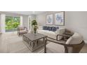 Bright living room with stylish furniture, neutral tones, and a sliding glass door to the outdoors at 1132 Moss Cove Ct, Port Charlotte, FL 33953