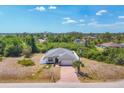 Birds-eye view of a lovely single-Gathering home with a two-car garage, a brick-paved driveway and a fenced backyard at 118 Boxwood Ln, Rotonda West, FL 33947
