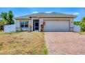 Close-up of a single-Gathering home with a two-car garage and a brick-paved driveway at 118 Boxwood Ln, Rotonda West, FL 33947