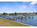 Scenic waterfront view featuring boat docks, calm waters, and waterfront homes in the distance on a clear day at 124 Rotonda Cir, Rotonda West, FL 33947