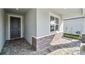 Covered front porch with stone accents, tiled flooring, and stylish front door at 16029 Mulrion Blvd, Punta Gorda, FL 33982
