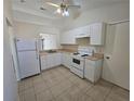 Bright kitchen featuring white cabinets, standard appliances, and tile flooring at 19583 Kapok Ct, Port Charlotte, FL 33952