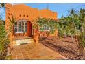Cozy coral home offering a tile patio, a blooming frangipani tree, and stylish privacy landscaping at 2002 Central Ave, Sarasota, FL 34234