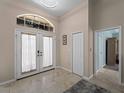 Bright foyer with tiled floors and arched window above double front doors for natural light at 2288 Prague Ln, Punta Gorda, FL 33983