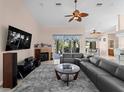 Spacious living room with a fireplace, tile flooring, ceiling fan, and access to outdoor living space at 2288 Prague Ln, Punta Gorda, FL 33983