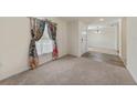 Bright living room featuring plush carpeting, natural light and colorful curtains at 23470 Burlingame Ave, Punta Gorda, FL 33980
