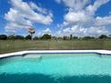 Private backyard with a sparkling pool and lush landscaping provides the perfect outdoor oasis at 2500 Aquilos Ct, Port Charlotte, FL 33952