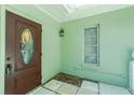 Inviting entryway with a wood door, light green walls, and tiled floor at 31037 Prairie Creek Dr, Punta Gorda, FL 33982