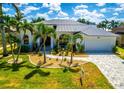 Charming home with a lush lawn, freshly landscaped garden beds, and a brick paved driveway with plenty of parking at 3520 Caya Largo Ct, Punta Gorda, FL 33950