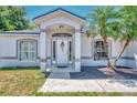 Welcoming front entrance with a decorative door, complemented by large windows and a meticulously kept lawn at 4129 Palisades Ave, North Port, FL 34287