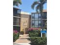 Exterior view of the Sandpiper building with lush landscaping and a walkway leading to the entrance at 618 Bird Bay S Dr # 109, Venice, FL 34285