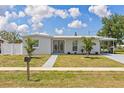 Attractive single-story home featuring a pristine lawn, covered parking and freshly painted exterior at 6309 Pontiac Ln, North Port, FL 34287