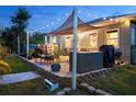 Relaxing backyard patio area with outdoor seating, overhead lighting, and a shade sail canopy at 7122 Turner St, Englewood, FL 34224