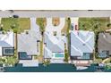 Aerial view of houses with a gray roof and a back yard with a pool and a boat dock with a boat attached at 8084 Burwell Cir, Port Charlotte, FL 33981