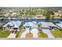 Beautiful waterfront home featuring a gray metal roof, an eye-catching turquoise trim, and a circular driveway at 8084 Burwell Cir, Port Charlotte, FL 33981