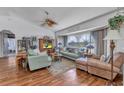 Cozy living room featuring hardwood floors, large windows, a ceiling fan, and comfortable seating at 1372 Annette St, Punta Gorda, FL 33980