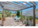 Cozy outdoor patio with pergola, seating area, and lush greenery, perfect for enjoying the serene surroundings at 142 Rotonda Cir, Rotonda West, FL 33947