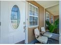 Inviting front porch with seating and decorative glass door, enhancing curb appeal at 159 Godfrey Ne Ave, Port Charlotte, FL 33952
