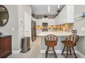 Modern kitchen featuring white cabinets, stainless steel appliances, quartz countertops, and a stylish breakfast bar at 1678 Royal Ct, Punta Gorda, FL 33980