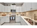 Beautiful kitchen with stainless steel appliances, elegant countertops, and ample storage in white cabinets at 1678 Royal Ct, Punta Gorda, FL 33980