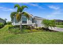 Charming single-story home with lush landscaping, mature palm trees, and a well-maintained lawn in a tranquil setting at 17459 Palmetto Pass Ln, Punta Gorda, FL 33982