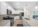 Bright kitchen features granite countertops, stainless steel appliances, white cabinetry, and a center island with a sink at 17459 Palmetto Pass Ln, Punta Gorda, FL 33982
