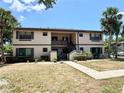 Charming two-story condo building featuring a lush lawn, mature palm trees, and well-kept landscaping at 19505 Quesada Ave # Ii201, Port Charlotte, FL 33948