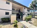 Two-story condo with well-kept landscaping, mature palms, and exterior stairs to the upper level at 19505 Quesada Ave # Ii201, Port Charlotte, FL 33948