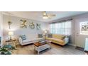 Cozy living room featuring stylish furnishings, bright windows, and modern ceiling fan at 20407 Albury Dr, Port Charlotte, FL 33952