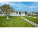 Well-kept single-story home with green lawn, walkway, and tree in the front yard at 2321 Dallas St, Port Charlotte, FL 33952