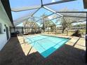 Inviting screened-in pool area with a clear blue pool, perfect for outdoor enjoyment at 261 Caddy Rd, Rotonda West, FL 33947