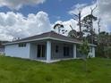 An inviting covered patio extends from the back of the home into the grassy yard, offering outdoor living at 298 Overbrook St, Port Charlotte, FL 33954