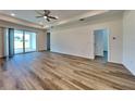 Spacious living room featuring wood-look floors, a ceiling fan and sliding glass doors to the patio at 298 Overbrook St, Port Charlotte, FL 33954