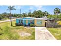 Single-story home features colorful exterior, mature palm trees, and a concrete driveway at 3927 Vasco St, Punta Gorda, FL 33950