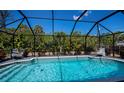 Inviting screened-in pool area with comfortable lounge chairs and lush landscaping at 4339 Boggs St, Port Charlotte, FL 33948