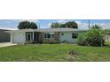 Inviting single-story home with lush lawn, stone details, and an attached one car garage at 570 Mimosa Nw Ave, Port Charlotte, FL 33952