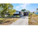 Inviting one-story residence with sunroom, covered carport, and landscaped front yard at 6144 Redwing Ave, Englewood, FL 34224