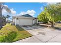 Street view of house with a two car garage, and green lawn at 6604 Ranger Dr, Tampa, FL 33615