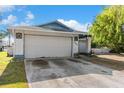 Home exterior with white garage door, trimmed with blue at 6604 Ranger Dr, Tampa, FL 33615