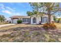 Quaint single-story home featuring an attached garage, well-kept landscaping, and cozy entrance at 6753 Thorman Rd, Port Charlotte, FL 33981