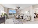 Inviting living room featuring comfortable seating, a ceiling fan, and a view of the pond at 9602 Turtle Grass Cir, Punta Gorda, FL 33950