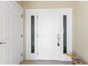 Entry door with sidelights and transom window, complimented by a pelican statue on tiled flooring at 101 N Marion Ct # 215, Punta Gorda, FL 33950