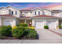 Inviting townhouse showcasing a well-manicured yard, red front doors, and convenient two-car garage at 1215 Jonah Dr, North Port, FL 34289