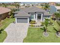 Beautiful single Gathering home features a well-manicured lawn, brick paved driveway, and a two car garage at 1330 Mineo Dr, Punta Gorda, FL 33950