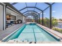 Enclosed pool area with a jacuzzi, a covered seating area, and an outdoor grilling space at 1330 Mineo Dr, Punta Gorda, FL 33950