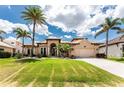Beautiful single Gathering home featuring a manicured lawn, mature palm trees, and a concrete driveway at 1367 Grebe Dr, Punta Gorda, FL 33950
