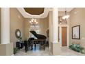 Grand foyer featuring tile floors, a baby grand piano, soaring ceilings, and custom lighting at 1367 Grebe Dr, Punta Gorda, FL 33950