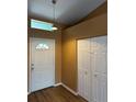 Inviting entryway featuring a front door with half-moon window and wood-look flooring at 16072 Galiano Ct, Punta Gorda, FL 33955