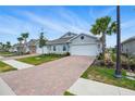 Charming home features a brick driveway, attached garage, and well-maintained landscaping at 16079 Bandermill Dr, Port Charlotte, FL 33953